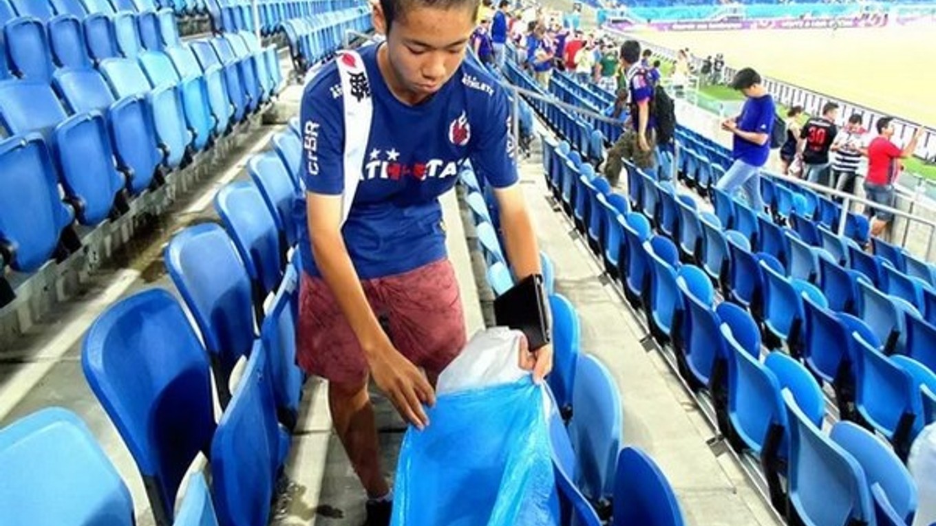 Japonský fanúšik upratuje neporiadok po zápase s Gréckom.