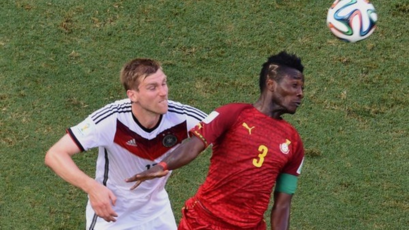 Per Mertesacker z Nemecka (vľavo) a futbalista Ghany Asamoah Gyan.
