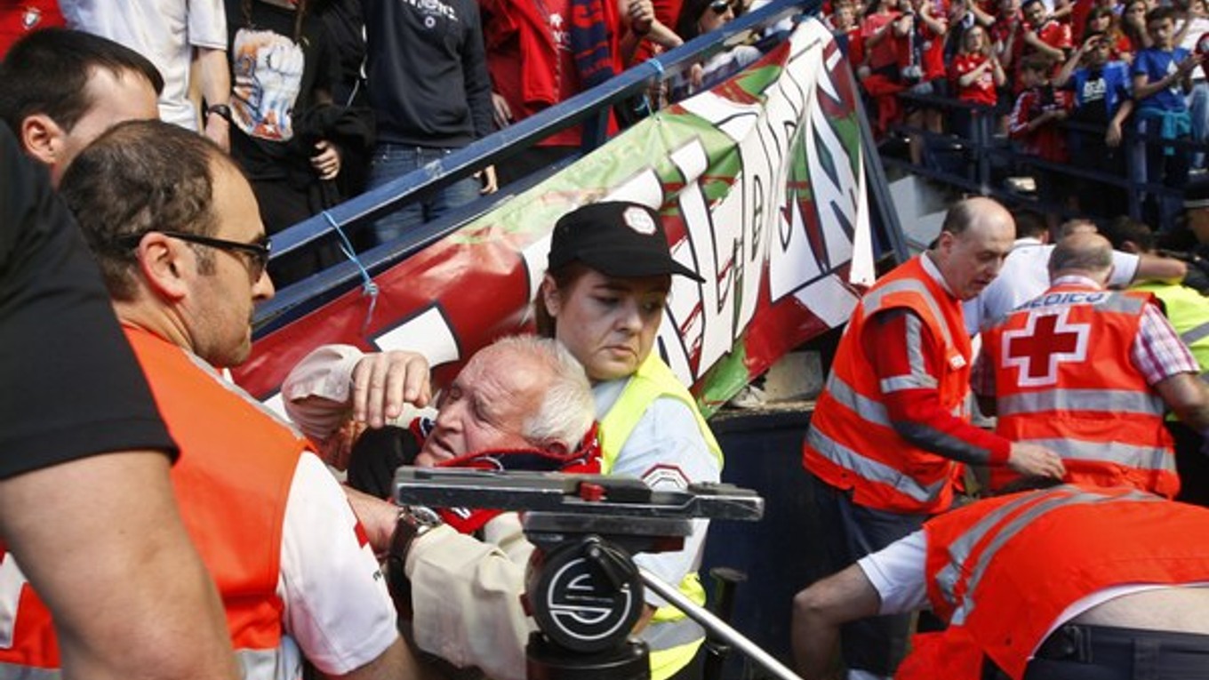 Záchranári pomáhajú fanúšikovi Osasuny po páde bariéry na štadióne.