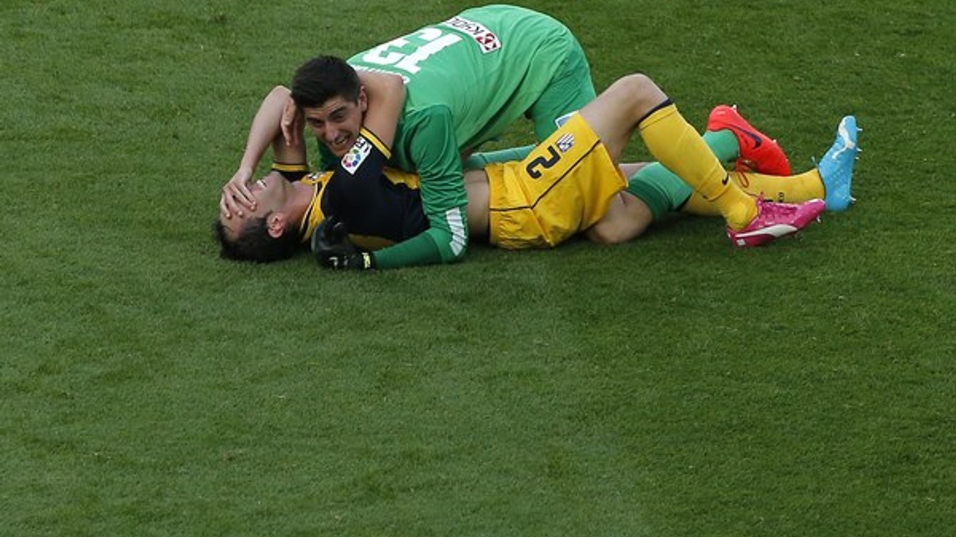 Thibaut Courtois (hore) a Uruguajčan Diego Godin oslavujú španielsky titul.