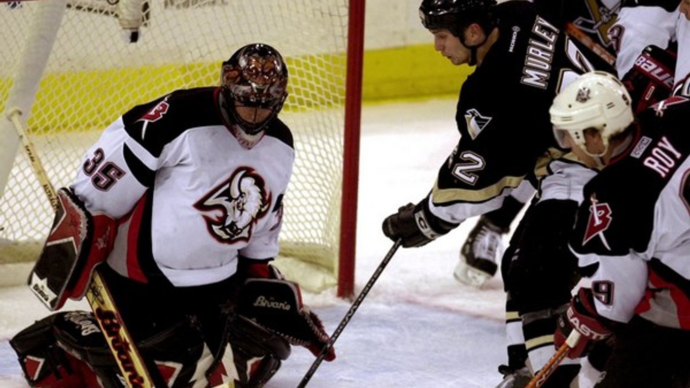 Brankár tímu Buffalo Sabres Fín Mika Noronen zasahuje proti strele Matta Murleyho (druhý zľava) z mužstva Pittsburgh Penguins počas zápasu NHL 16. decembra 2003.