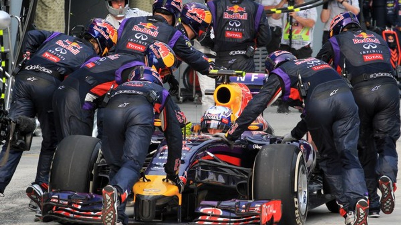 Mechanici tlačia Daniela Ricciarda po boxovej uličke.