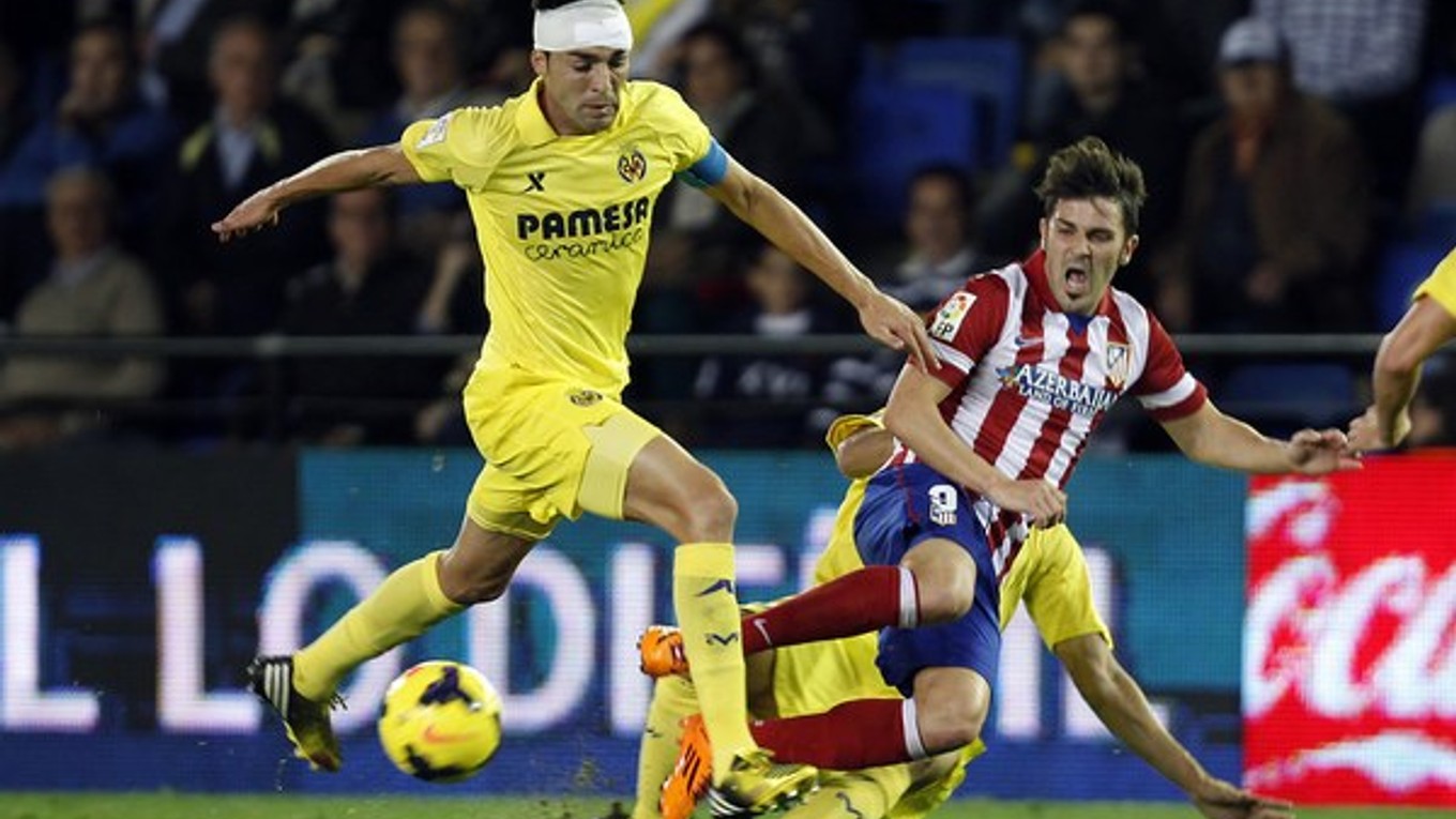 V žltom drese Soriano, futbalista FC Villarreal v súboji s Davidom Villom s Atlética Madrid.
