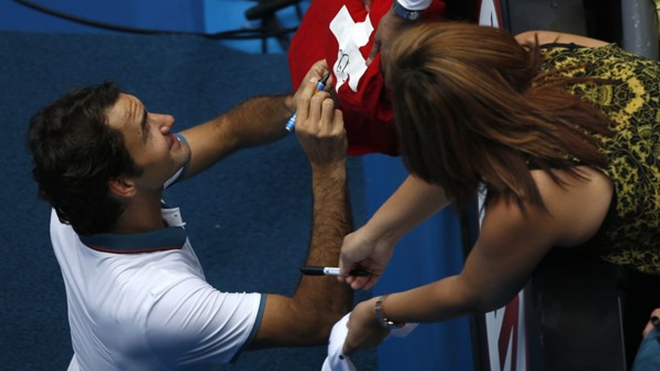 Roger Federer rozdáva autogramy po zápase.