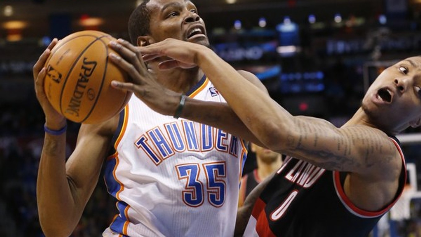 Basketbalista Oklahomy Kevin Durant sa snaží dostať cez Damiana Lillarda z Portlandu.