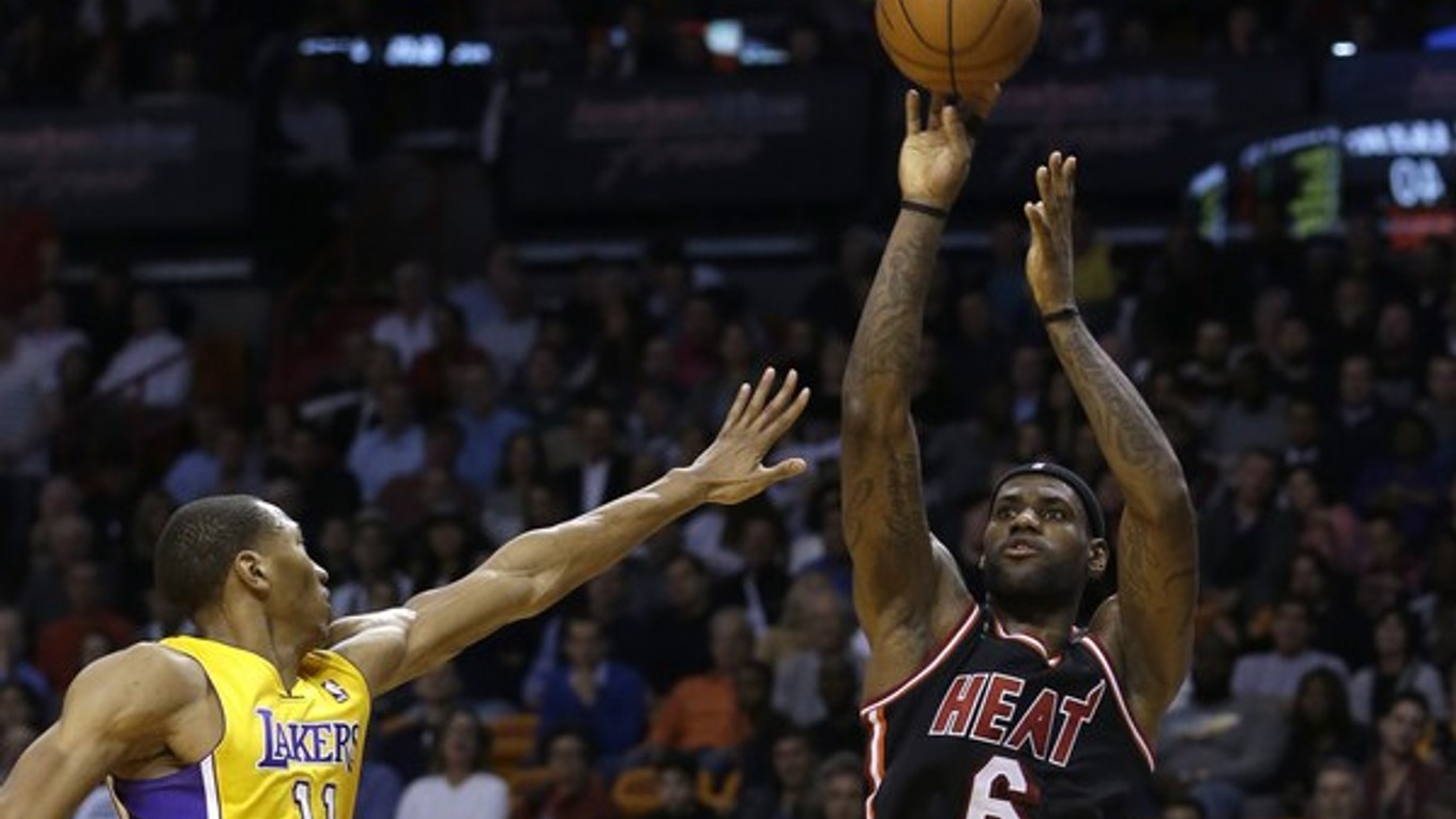 LeBron James z Miami Heat strieľa, vľavo k nemu nestíha pristúpiť Wesley Johnson z Los Angeles Lakers.