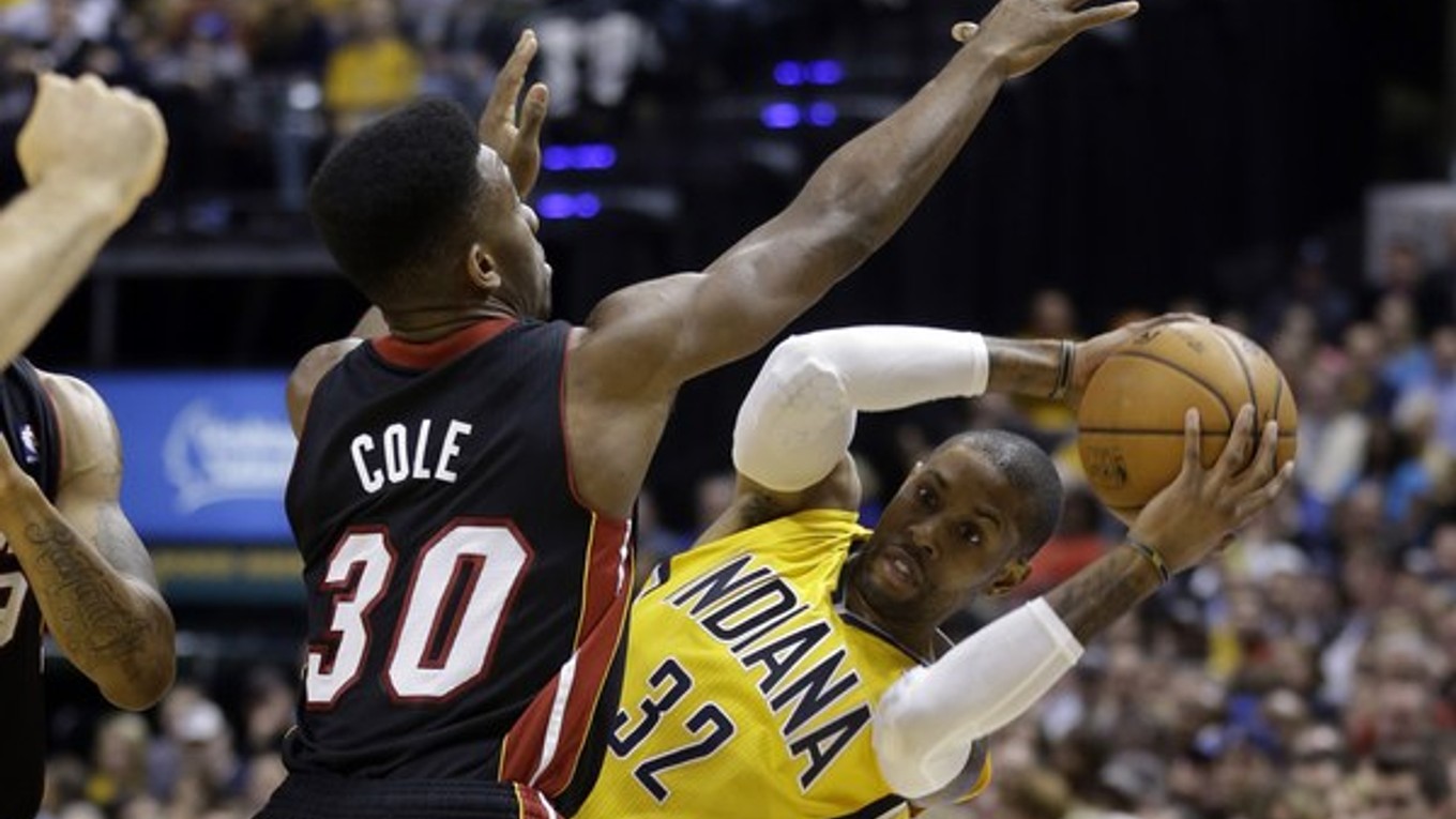 Rozohrávač tímu Indiana Pacers C.J. Watson (vpravo) sa snaží dostať loptu cez rozohrávača tímu Miami Heat Norrisa Colea.