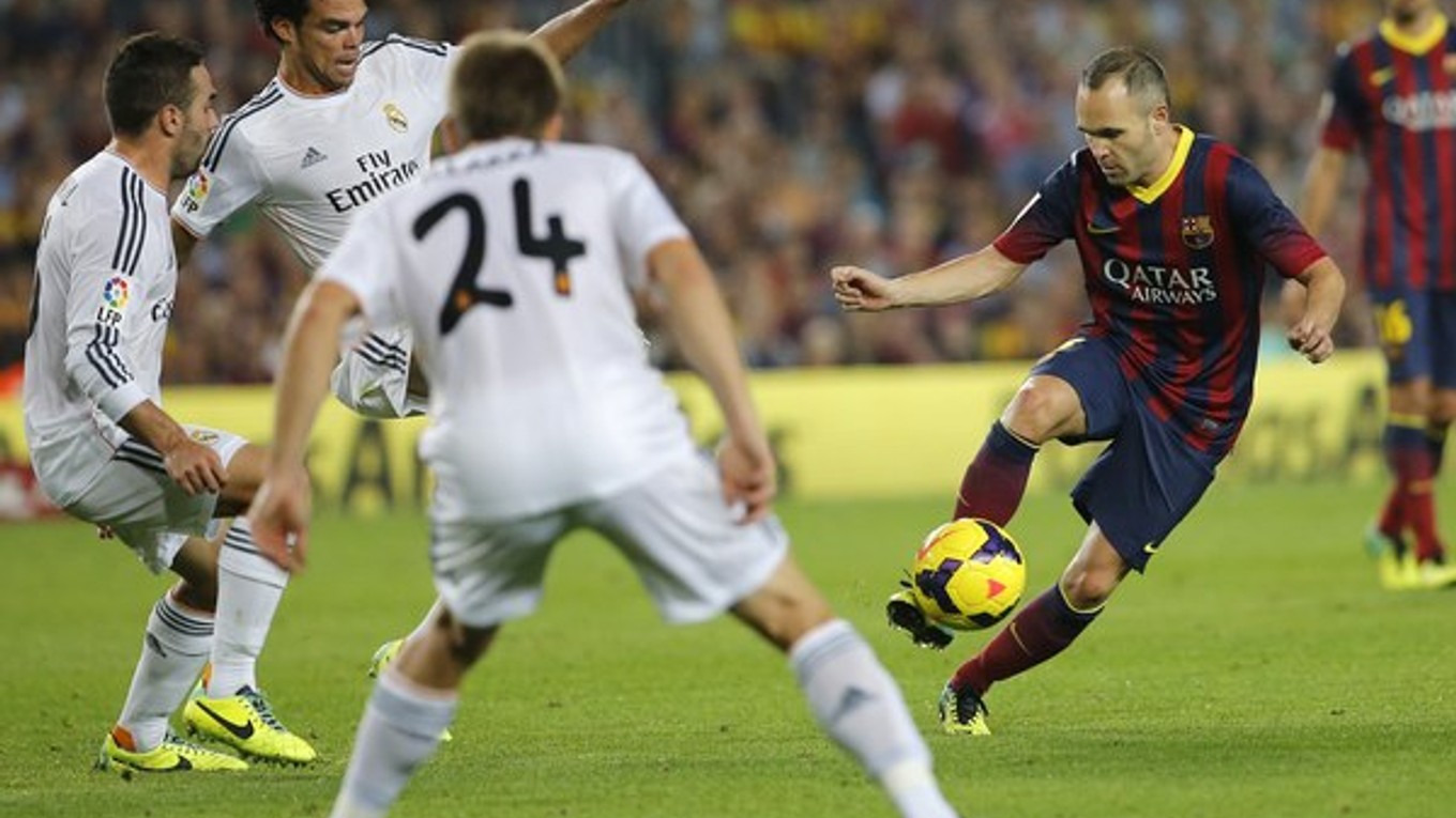 Iniesta v súboji s hráčmi Realu.