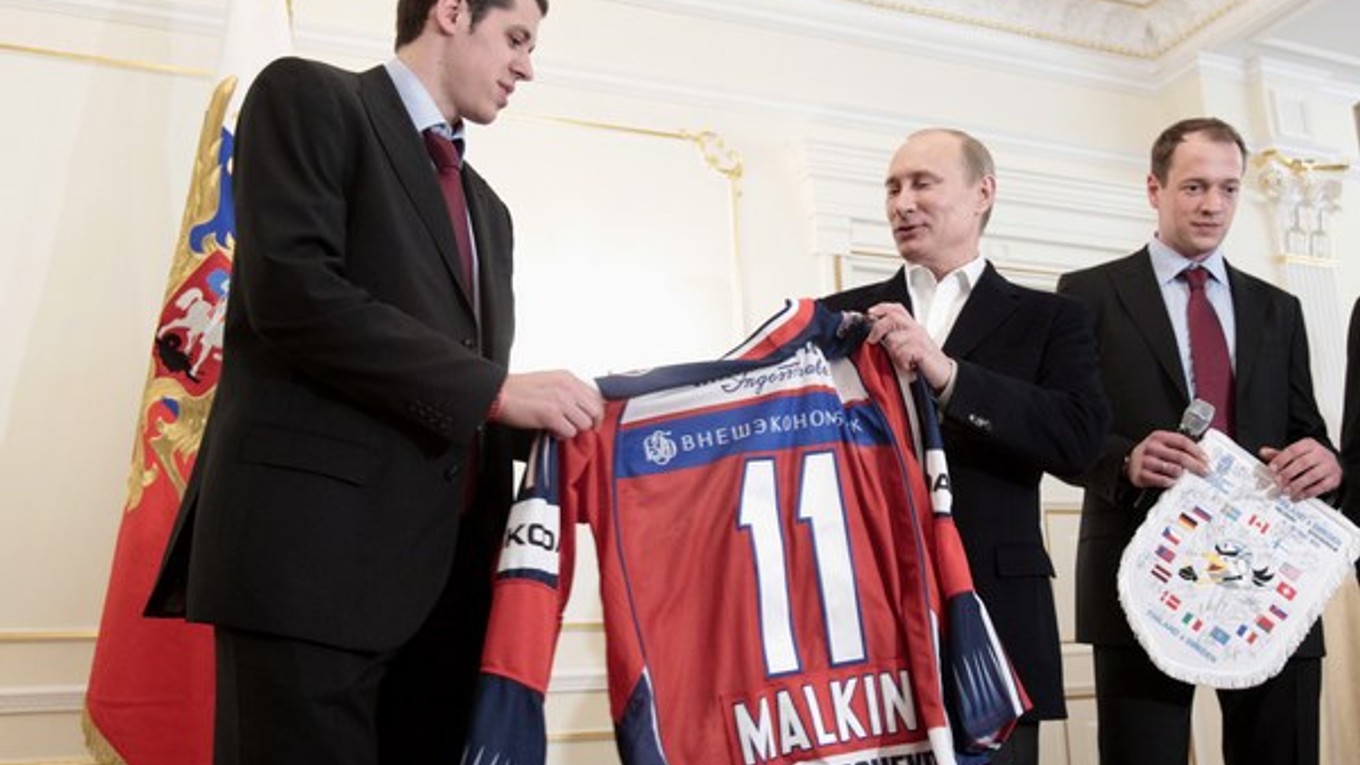 Ruský  prezident  Vladimir Putin si preberá  dres z rúk  hviezdy ruského reprezentačného tímu Jevgenija Malkina.