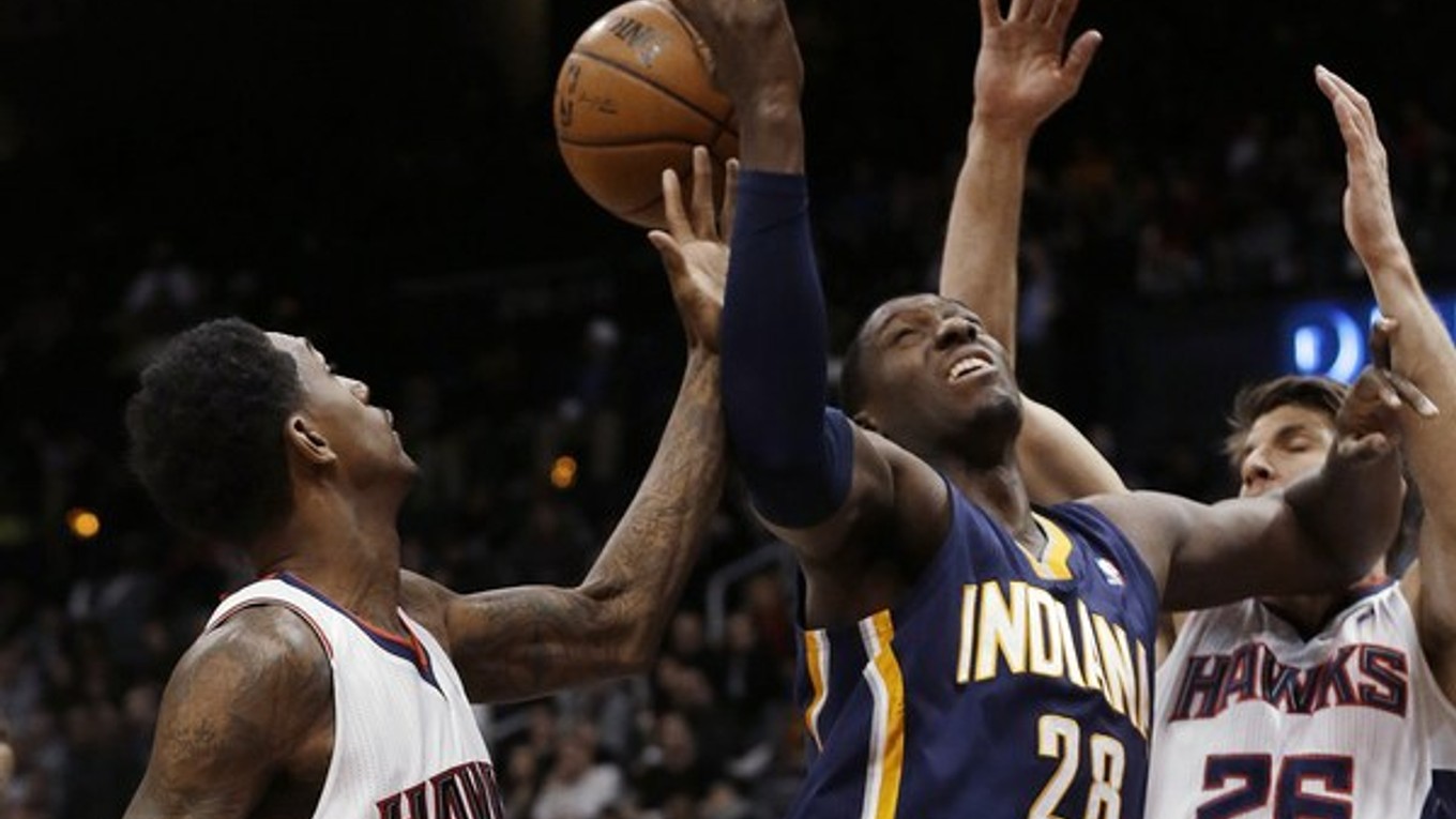 Ian Mahinmi z tímu Indiana Pacers (28) medzi hráčmi tímu Atlanta Hawks Kyleom Korverom (26) a Louisom Williamsom.