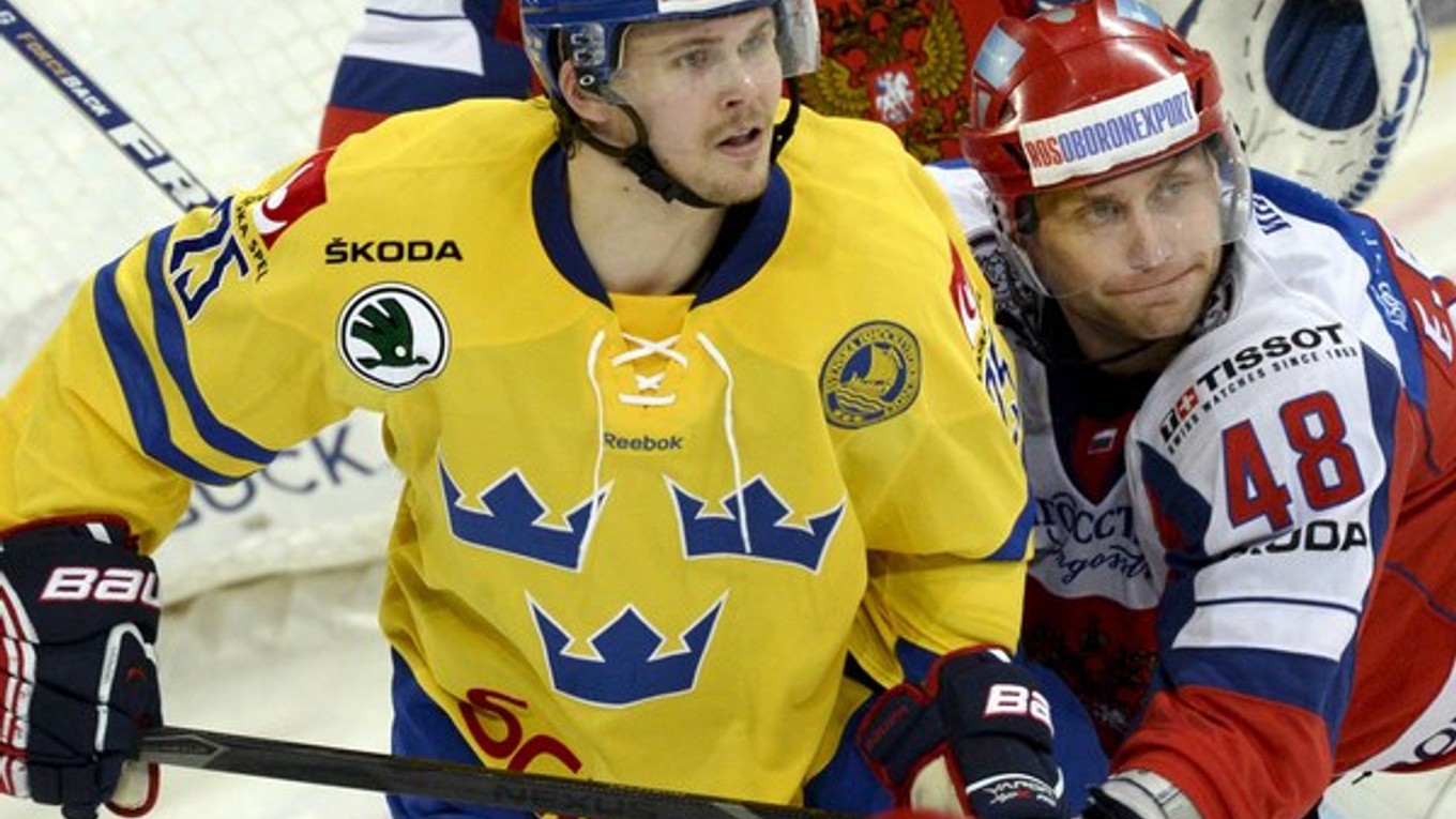 Ruský hokejista Jevgenij Birjukov a švédsky hokejista David Ullström v zápase Euro Hockey Tour na Karjala Cupe medzi Švédskom a Ruskom.
