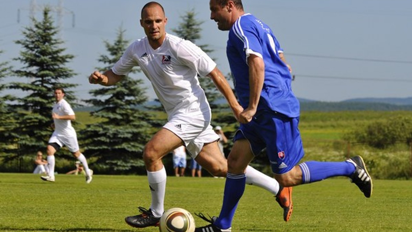 Hokejista Andrej Sekera sa snaží odstaviť od lopty futbalistu Ladislava Pecka počas priateľského futbalového zápasu medzi slovenskou hokejovou reprezentáciou a slovenskými futbalovými internacionálmi v Štrbe.