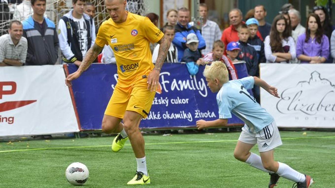 Martin Škrtel v súboji o loptu s mladým slovanistom počas piateho ročníka charitatívneho turnaja Hviezdy deťom 30. júna 2013 v Trenčíne.