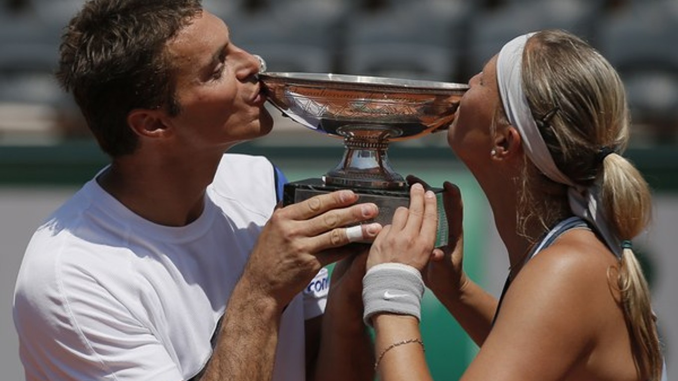 Český tenisový pár Lucie Hradecká a František Čermák bozkávajú trofej po ich víťazstve vo finále miešanej štvorhry.