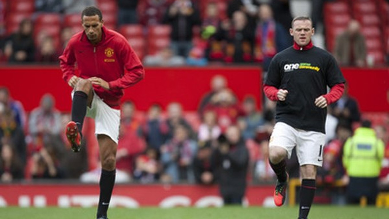 Ferdinand (vľavo) so rozcvičuje v oblečení svojho klubu, jeho spoluhráč Rooney má na sebe tričko "Vykopnime rasizmus z futbalu".