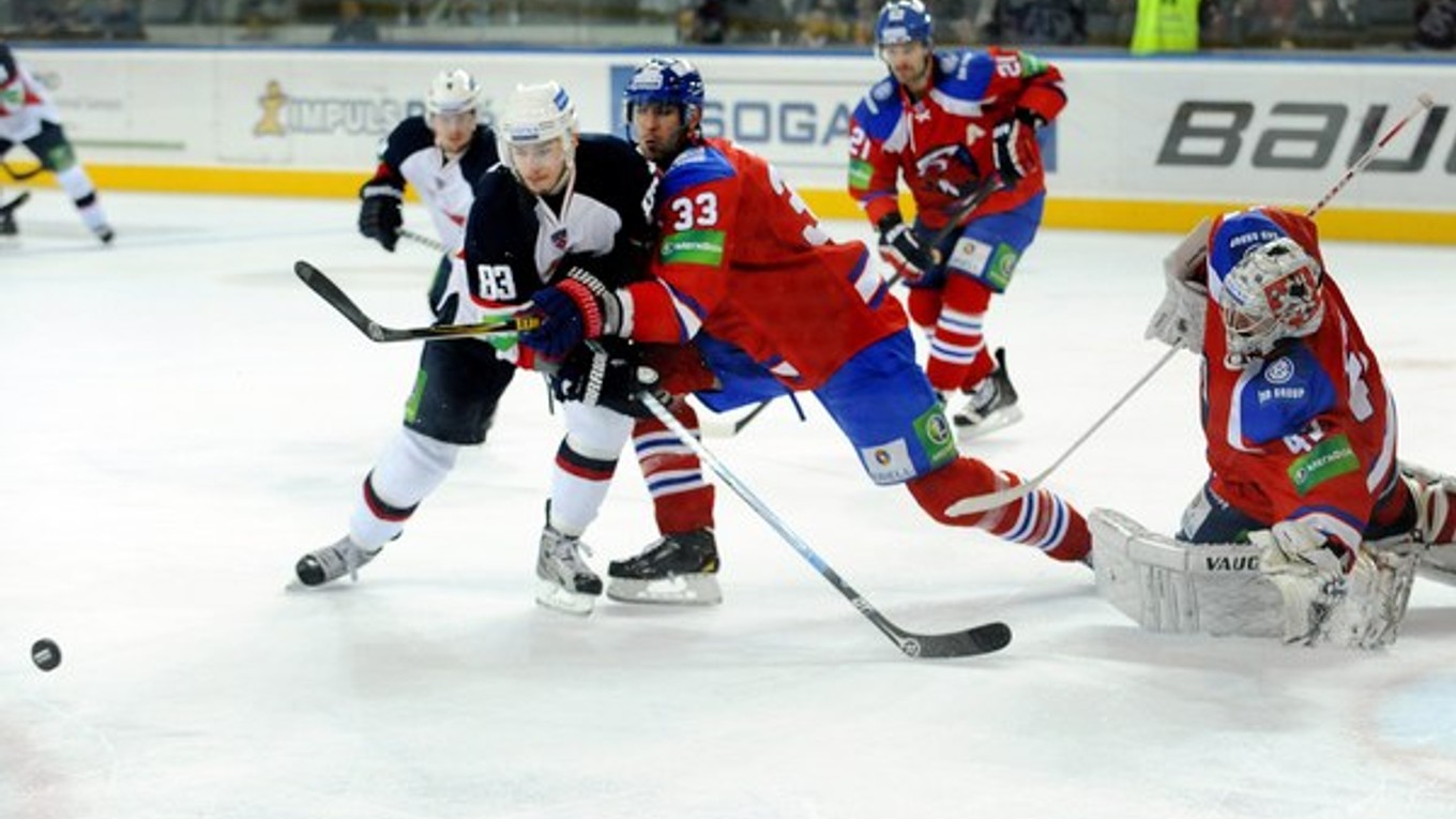 Zdeno Chára (č. 33) v súboji o puk s Martinom Bakošom. V prvom vzájomnom zápase v KHL v Prahe vyhral Slovan 2:1. V sobotu o 17.00 sa hrá v Bratislave odveta.