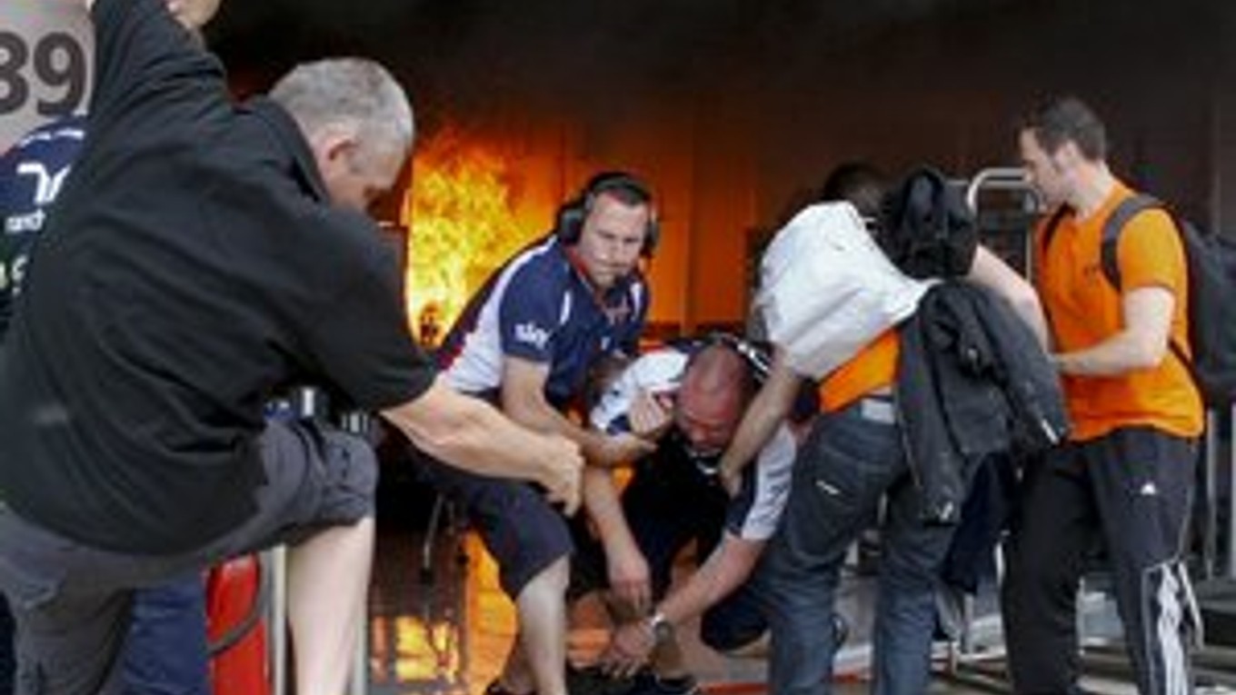 Zraneného člena tímu Williams vynášajú z priestorov, kde vypukol požiar.