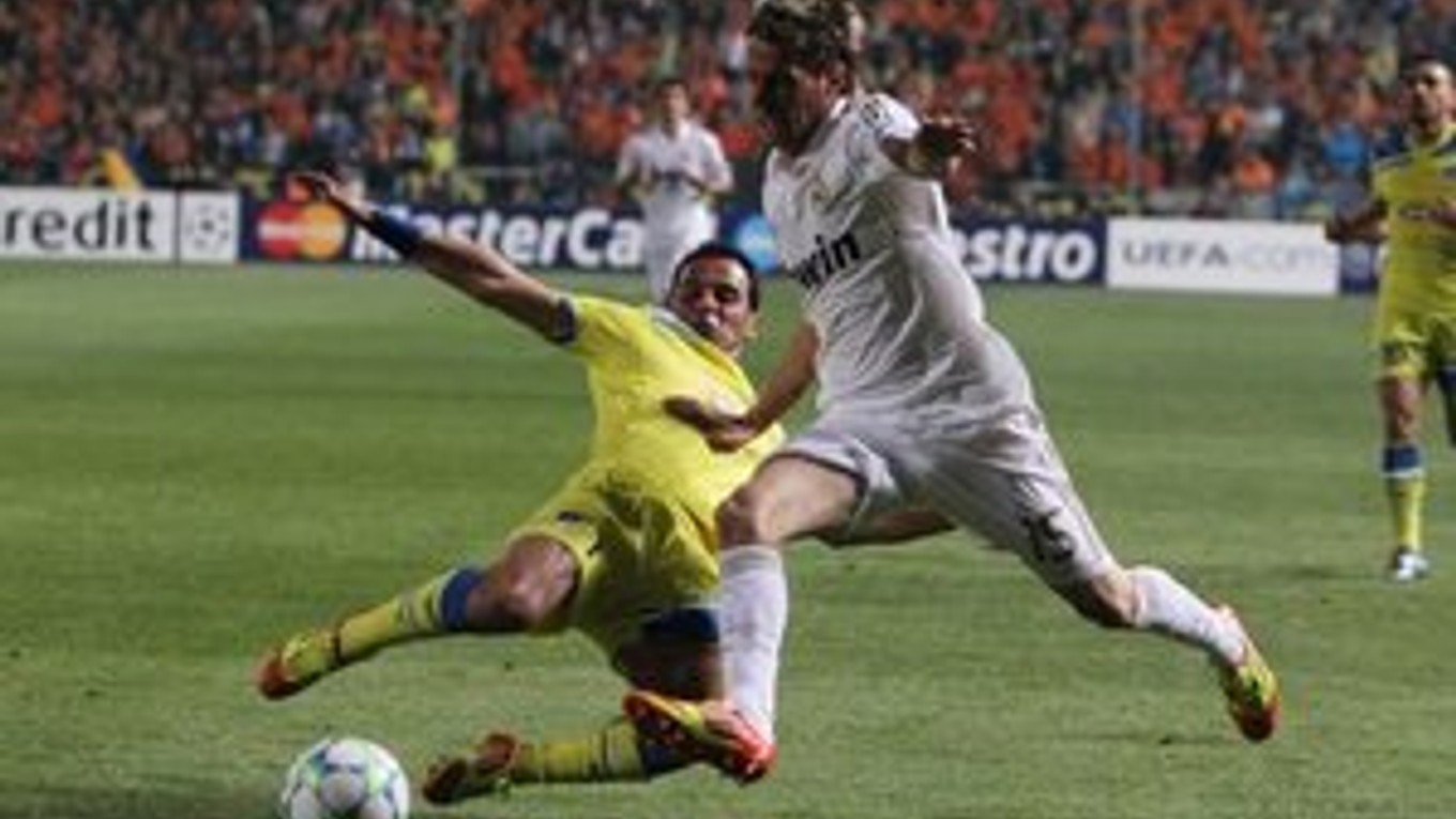 Savvas Poursaitides (APOEL, v žltom) v súboji Fabiom Coentraom z Realu.