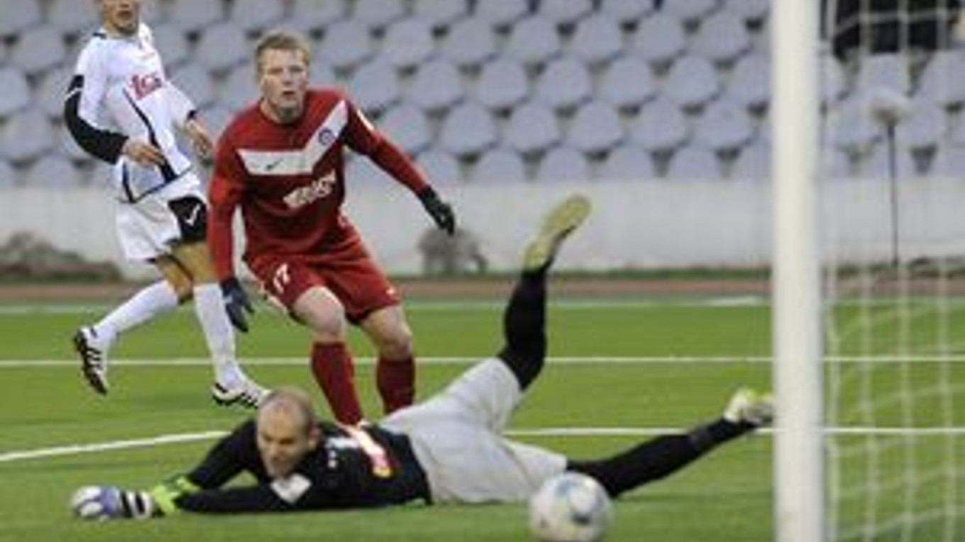 Trnavčan Radoslav Ciprys (vľavo) strieľa gól cez brániaceho Trenčana Petra Čögleya (uprostred) a brankára Miloša Volešáka.