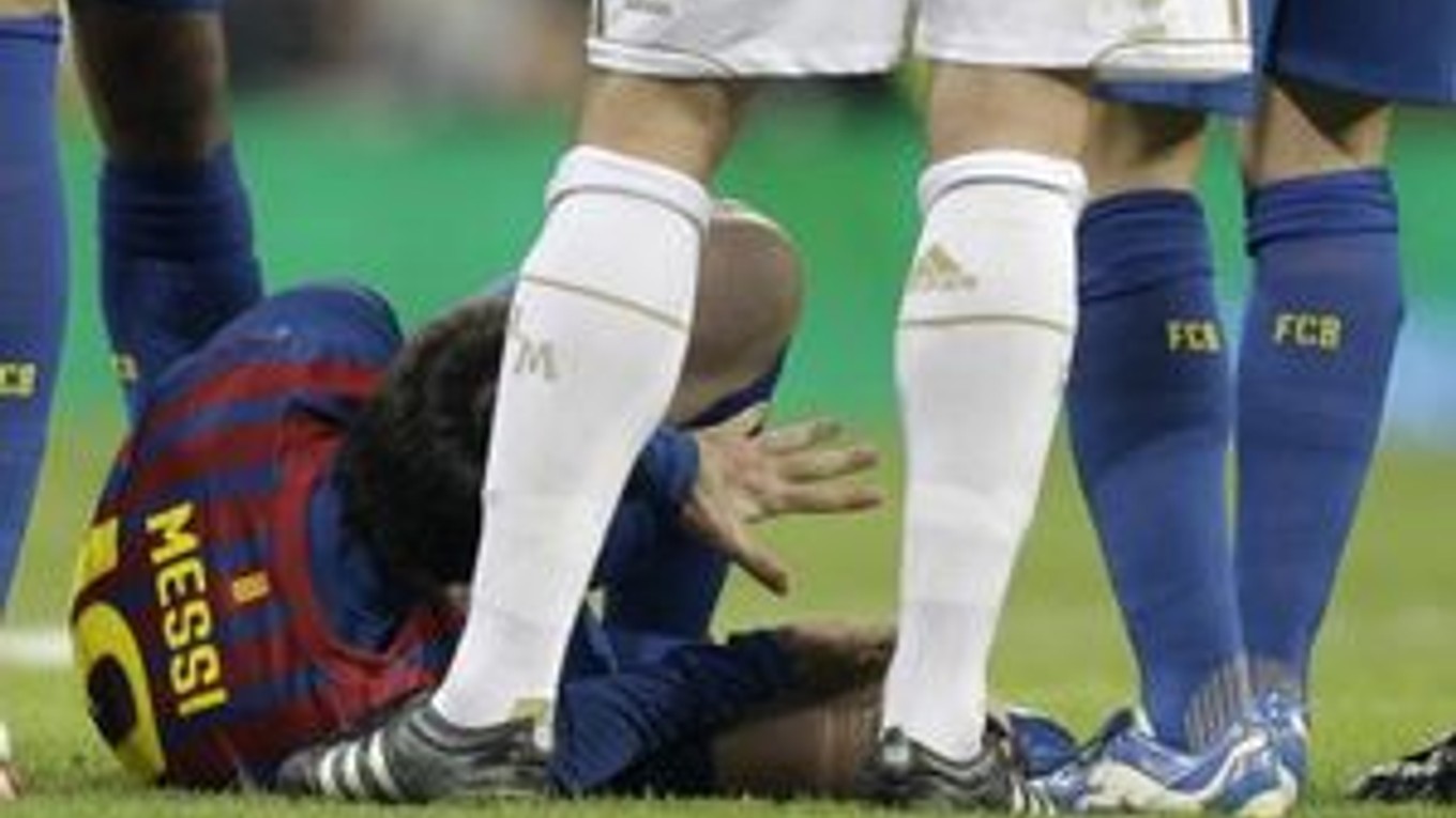 Lionel Messi leží na zemi po tom ako mu stúpil na ruku obranca Pepe.