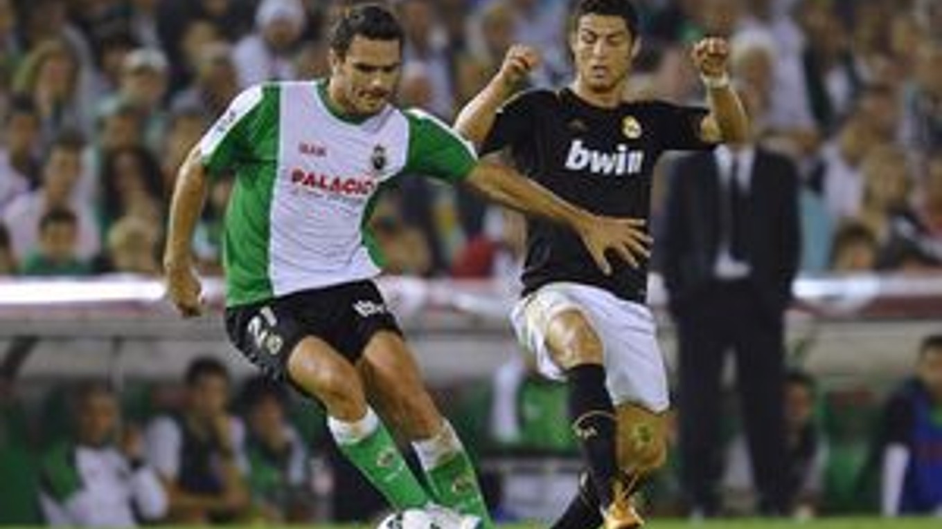 Portugalský útočník Realu Madrid Cristiano Ronaldo (vpravo) v súboji o loptu s Grékom v drese Racingu Santander Alexandrosom Tziolisom.