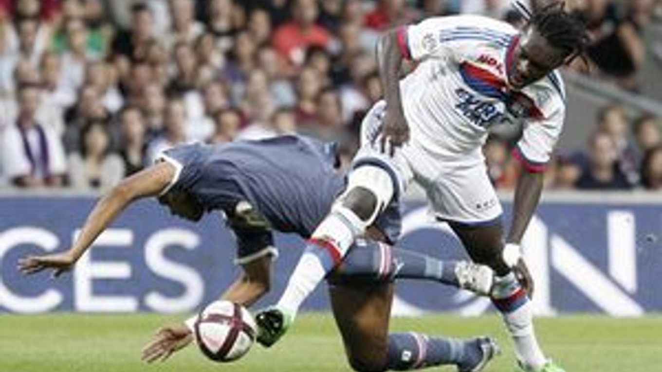 Futbalista Lyonu Bafe Gomis (vpravo) a hráč Bordeaux Carlos Henrique Dos Santos Souza bojujú o loptu počas zápasu francúzskej Ligue 1 v Lyone.