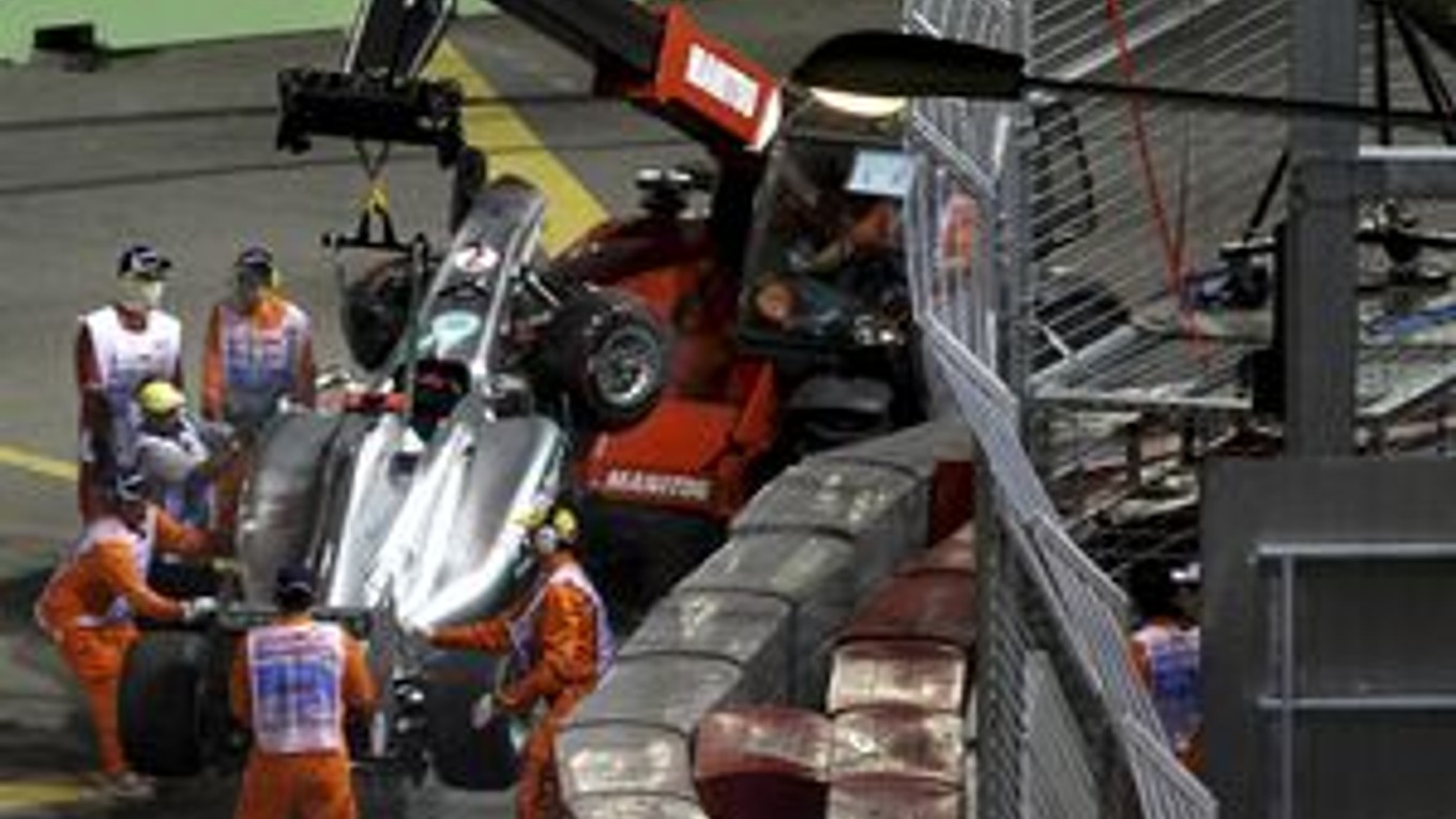 Monopost Michaela Schumachera odvážajú po nehode na Singapurskej Veľkej cene.