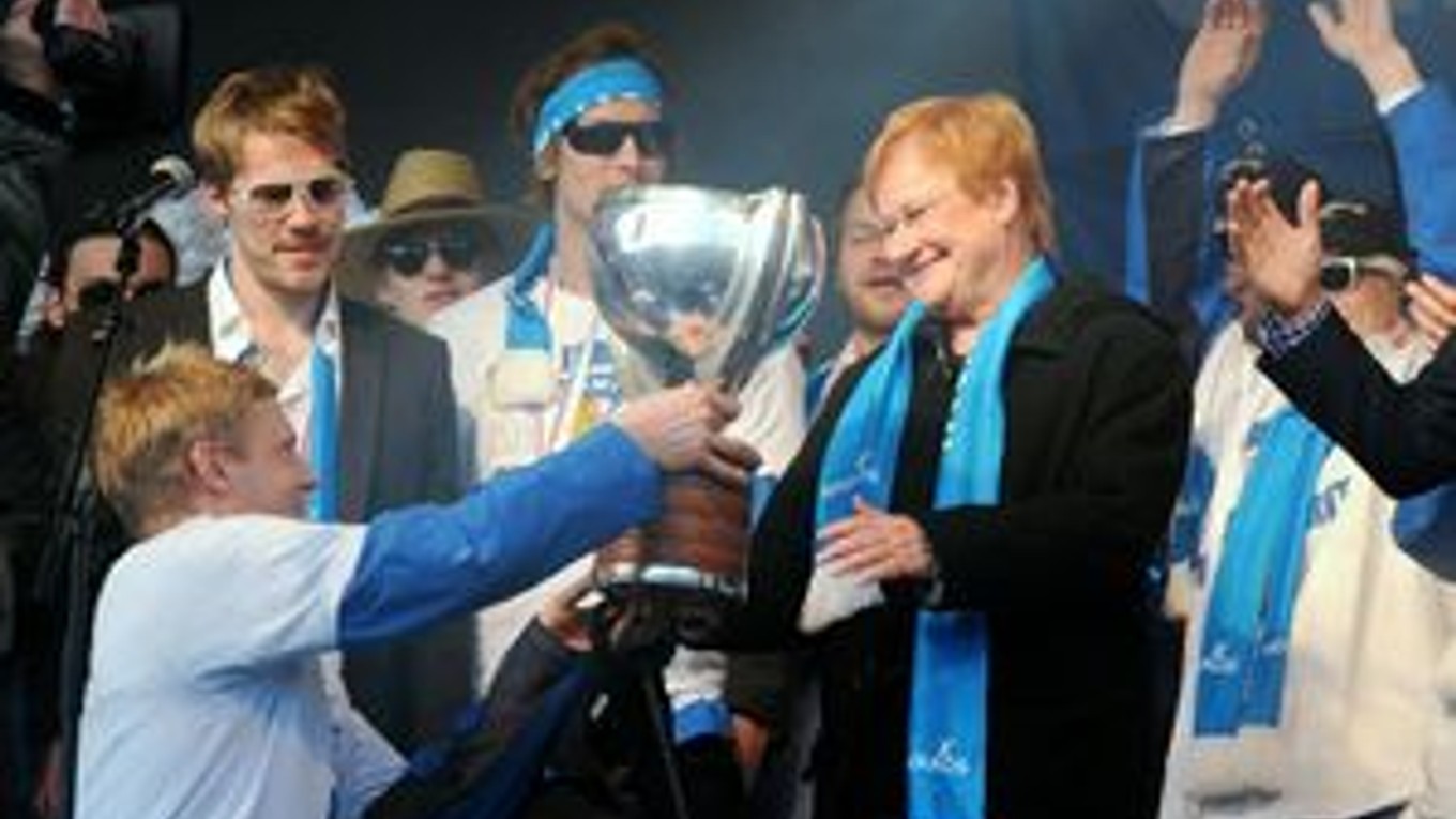 Fínsky kapitán Nikko Koivu dáva pohár majstrov sveta prezidentke republiky Tarji Halonenovej.