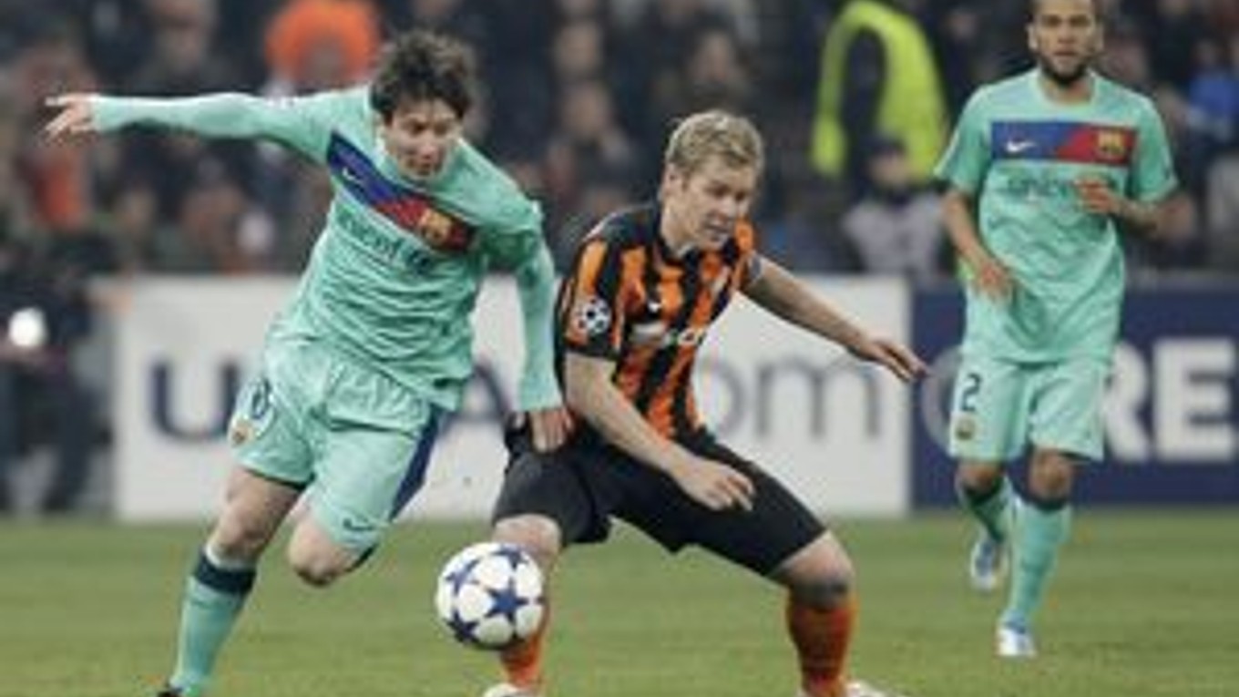 Lionel Messi (vľavo) bojuje o loptu s hráčom Šachtaru Tomášom Hübschmanom.