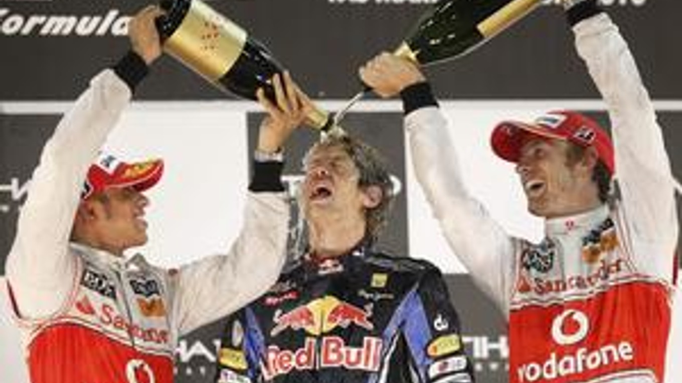 Sebastian Vettel na stupňoch víťazov s predošlými majstrami sveta F1 Lewisom Hamiltonom (vľavo) a Jensonom Buttonom.