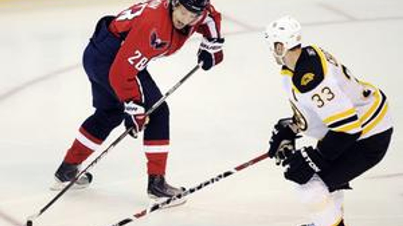 Kapitán Bostonu Zdeno Chára v súboji s Rusom Alexandrom Seminom z Washingtonu Capitals.