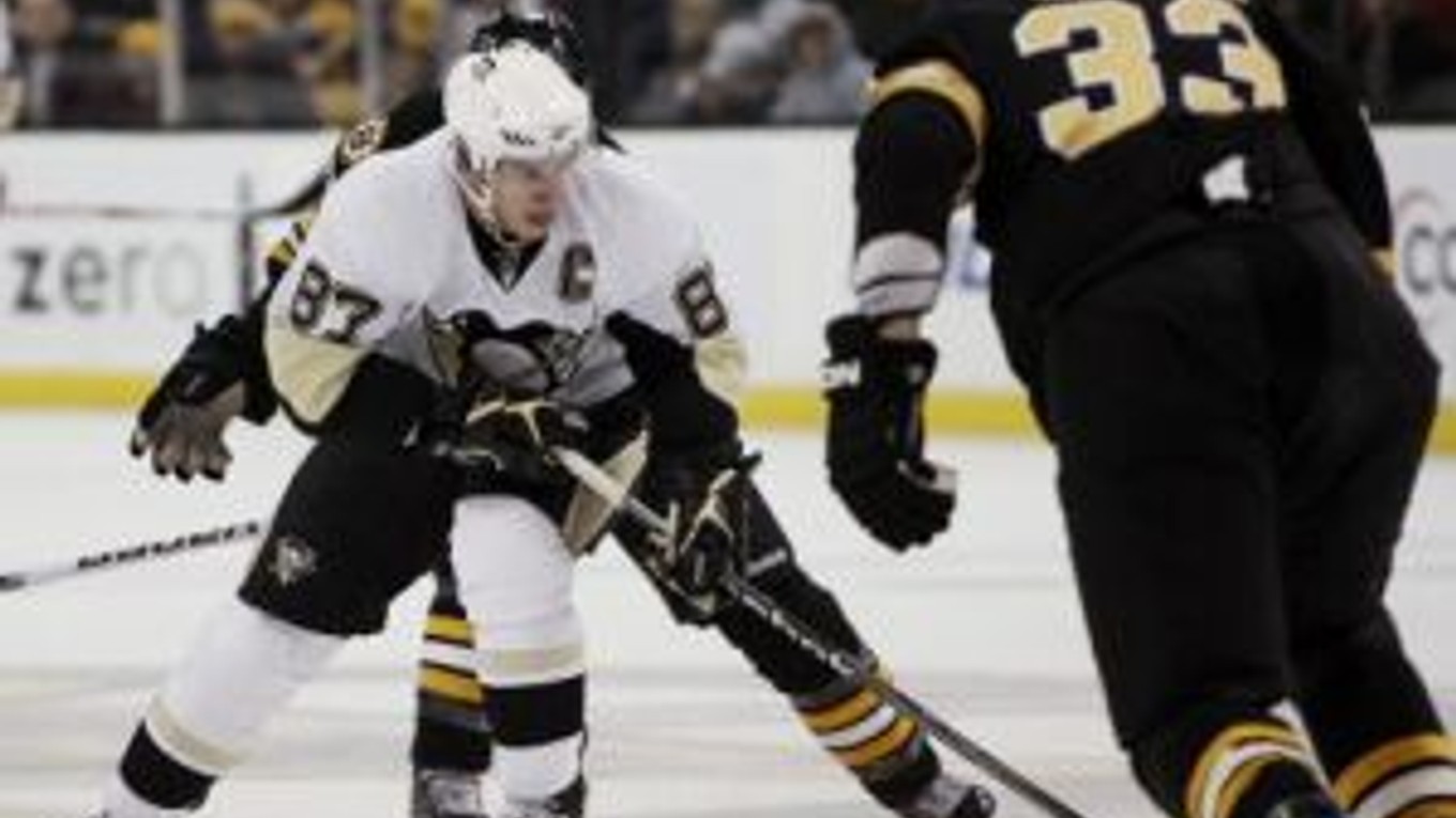 Sidney Crosby (87) z tímu Pittsburgh Penguins s pukom pred blížiacim sa slovenským obrancom mužstva Boston Bruins Zdenom Chárom.