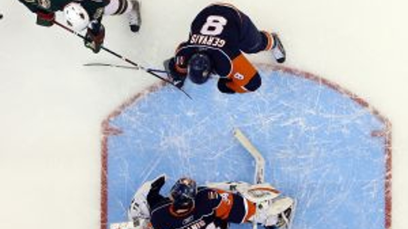 Marián Gáborík (hore v bielom) bránený Brunom Gervaisom prekonáva brankára NY Islanders Yanna Danisa.