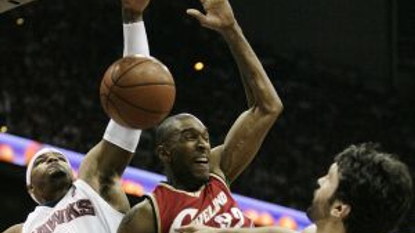 Joe Smith z Clevelandu (v červenom) zakončuje bránený dvojicou hráčov Atlanty Hawks.