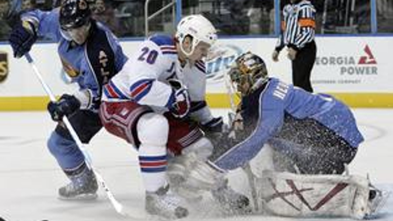 Brankár Johan Hedberg (vpravo) a Garnet Exelby (vľavo) z Atlanty zasahujú proti Fredrikovi Sjostromovi z Rangers v zápase NHL Atlanta - New York Rangers 2:3 pp.