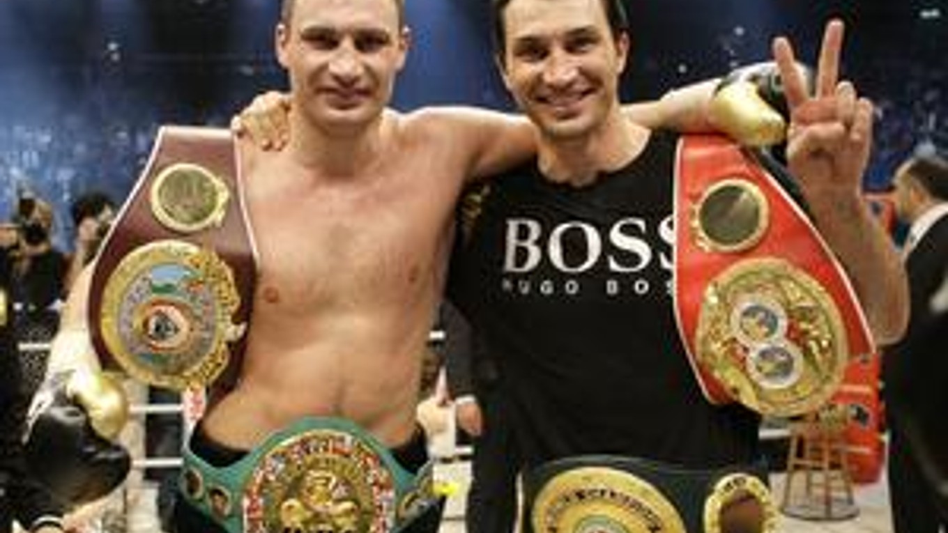 Ukrajinský boxer Vitalij Kličko (vľavo) a jeho brat Vladimir pózujú po skonče zápasu o titul majstra sveta v ťažkej váhe verzie WBC, v ktorom Vitalij porazil Nigérijčana Samuela Petera.