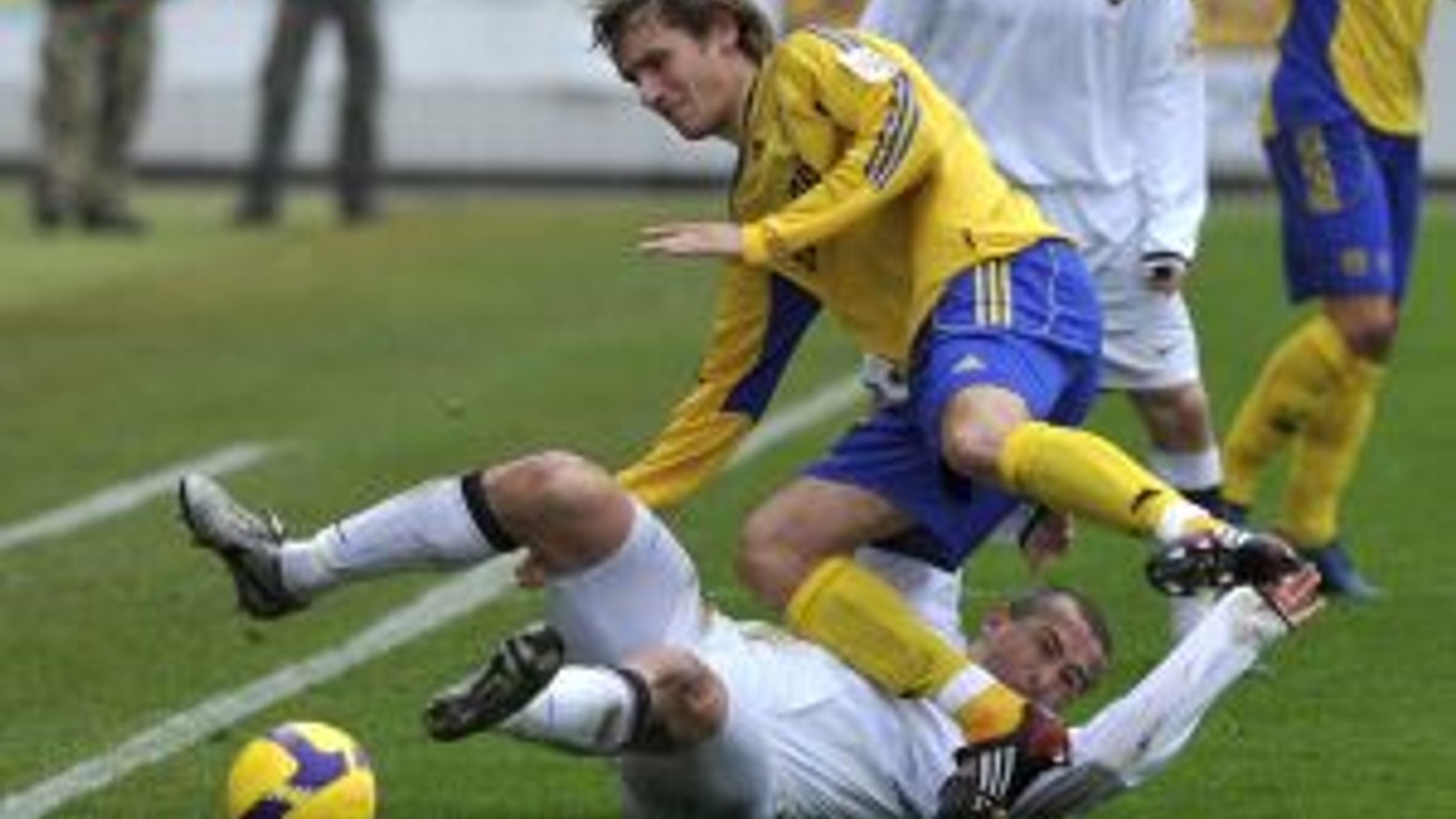 Košičan Lukáš Jančič padá cez Trnavčana Vladimíra Kožucha (na tráve).