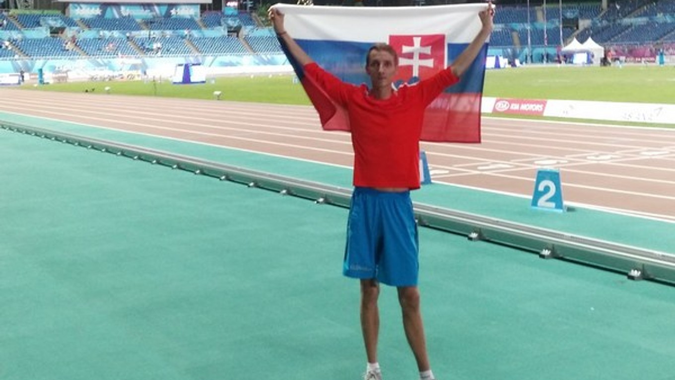 Lukáš Beer. Pózuje so slovenskou vlajkou na atletickom štadióne v Gwangju.