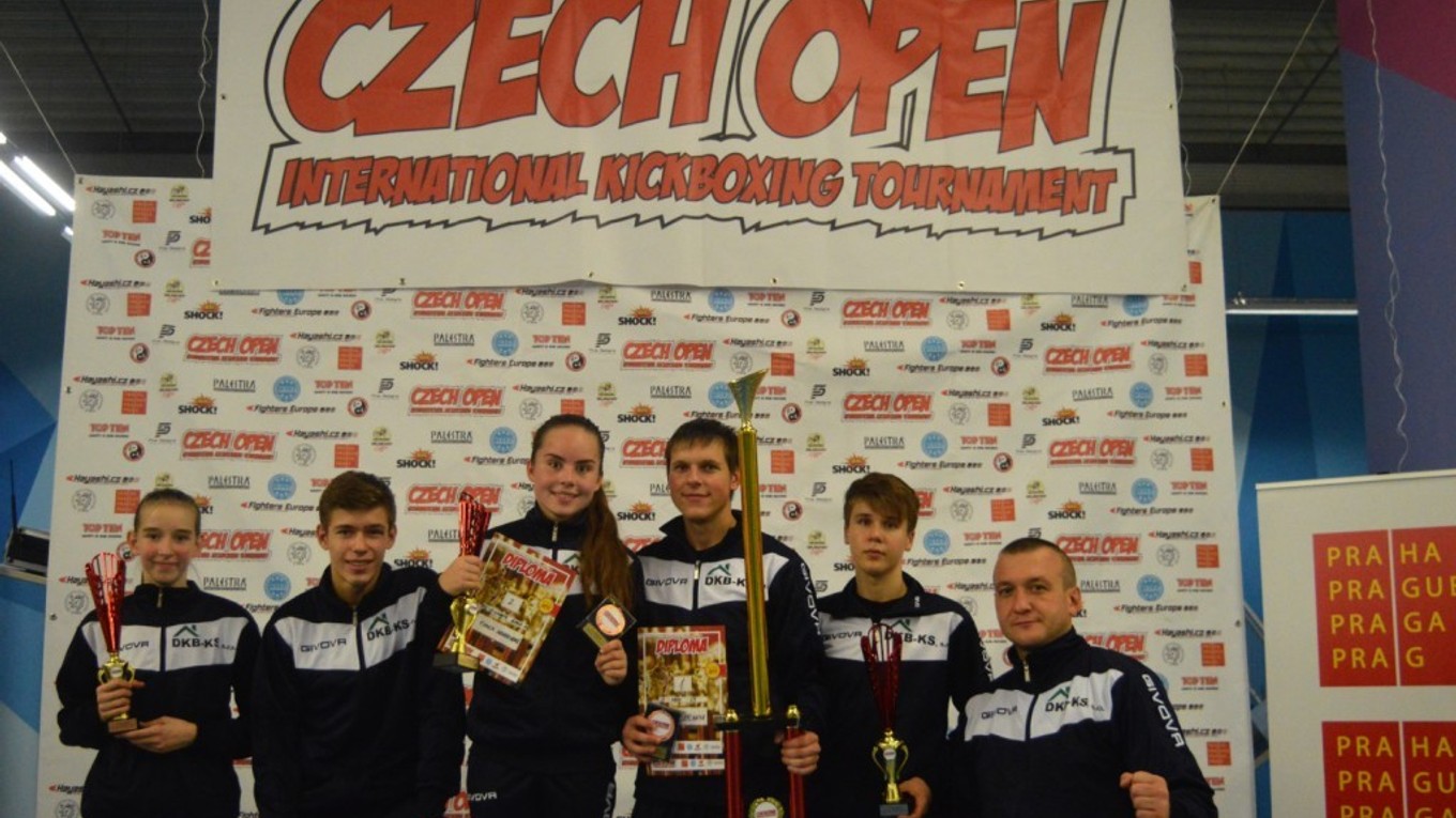 Michalovskí kickboxeri s trofejami, vpravo tréner Takáč.