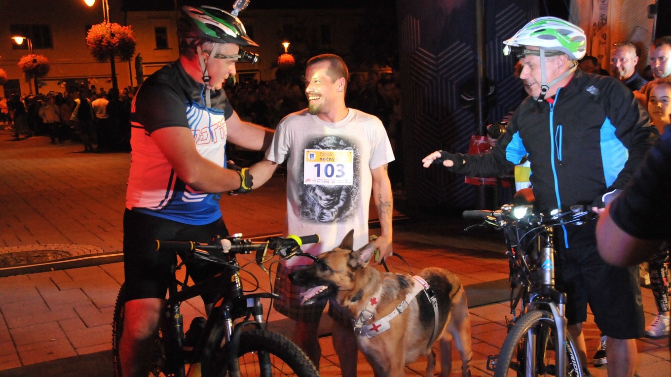 Nevidiaci bežec Andrej Farkaš (v strede) so svojím psom - fenkou Tarou na nočnom behu v Topoľčanoch.