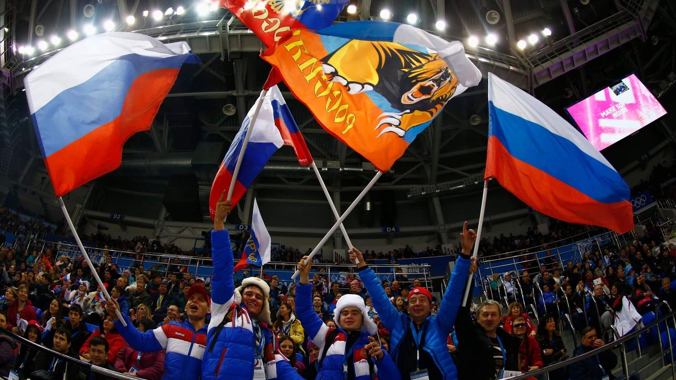 Hokejoví fanúšikovia s ruskými vlajkami na zimných hrách v Soči 2014. 