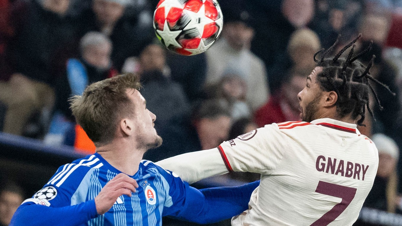 Serge Gnabry (Bayern) a Jurij Medveděv (Slovan)v súboji o loptu počas zápasu Ligy majstrov vo futbale Bayern Mníchov - Slovan Bratislava v Mníchove.