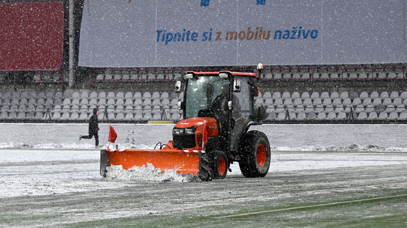 Traktor odhŕňa sneh pred zápasom Trenčín - Podbrezová.