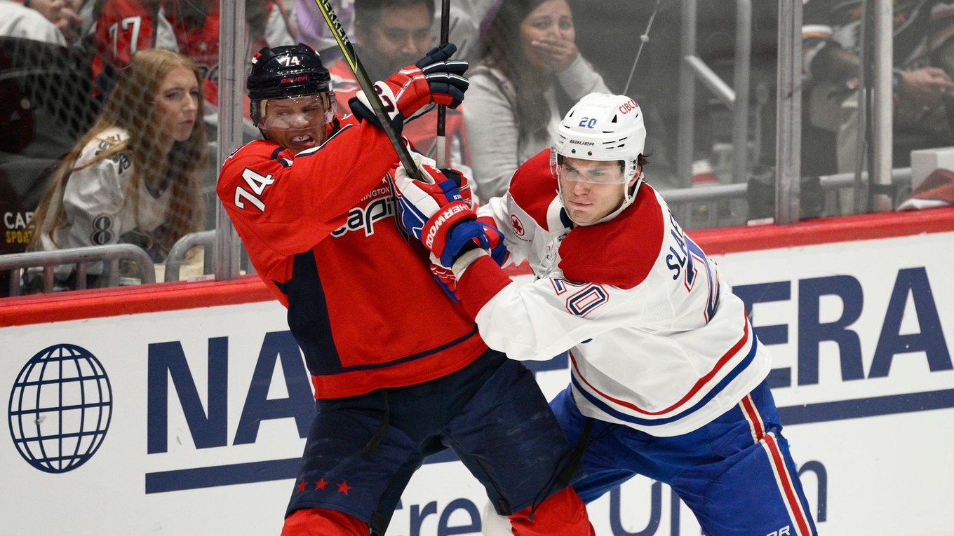 Juraj Slafkovský (Montreal) a John Carlson (Washington) v súboji o puk. 
