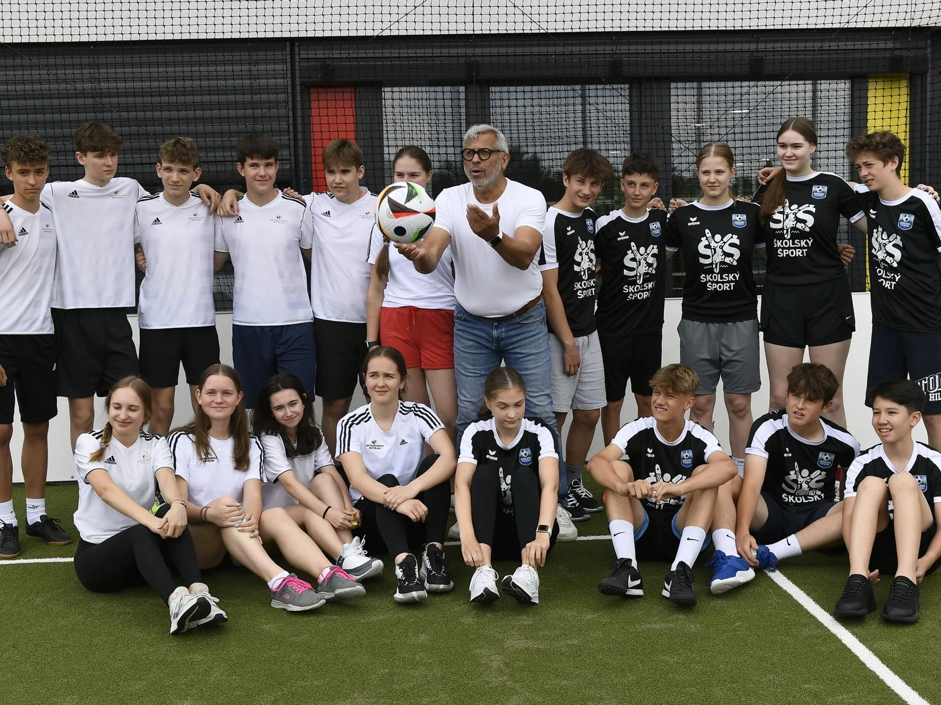 Futbalový vyslanec UEFA EURO 2024 Jimmy Hartwig (uprostred) pózuje so žiakmi Nemeckej školy Bratislava.