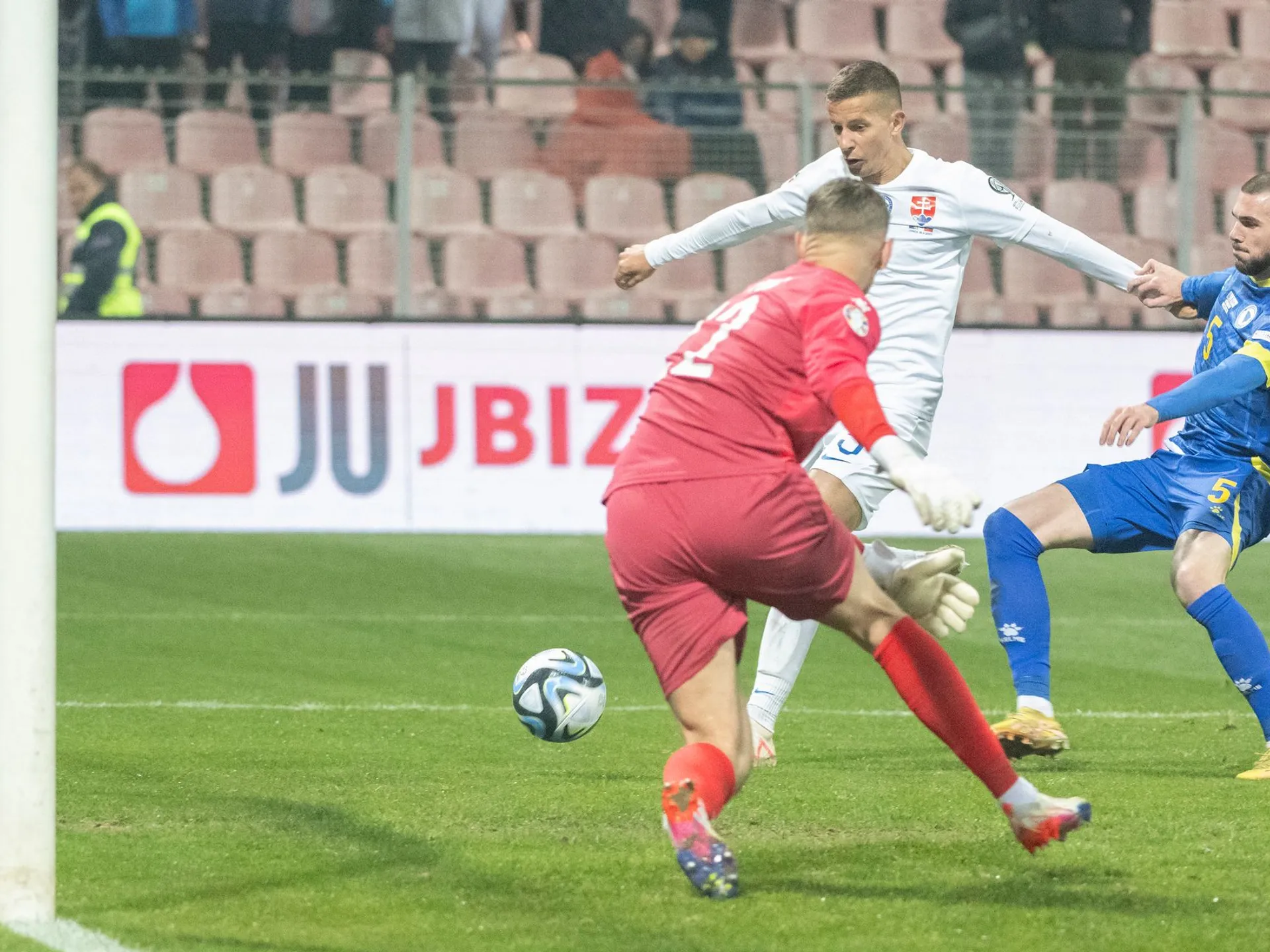 Na snímke slovenský futbalista Ľubomír Šatka (uprostred) strieľa gól na 1:2, vľavo brankár Bosny Kenan Pirič a vpravo jeho spoluhráč Nihad Mujakič v kvalifikačnom zápase záverečného 10. kola J-skupiny ME 2024 Bosna a Hercegovina - Slovensko v Zenici v nedeľu 19. novembra 2023. 