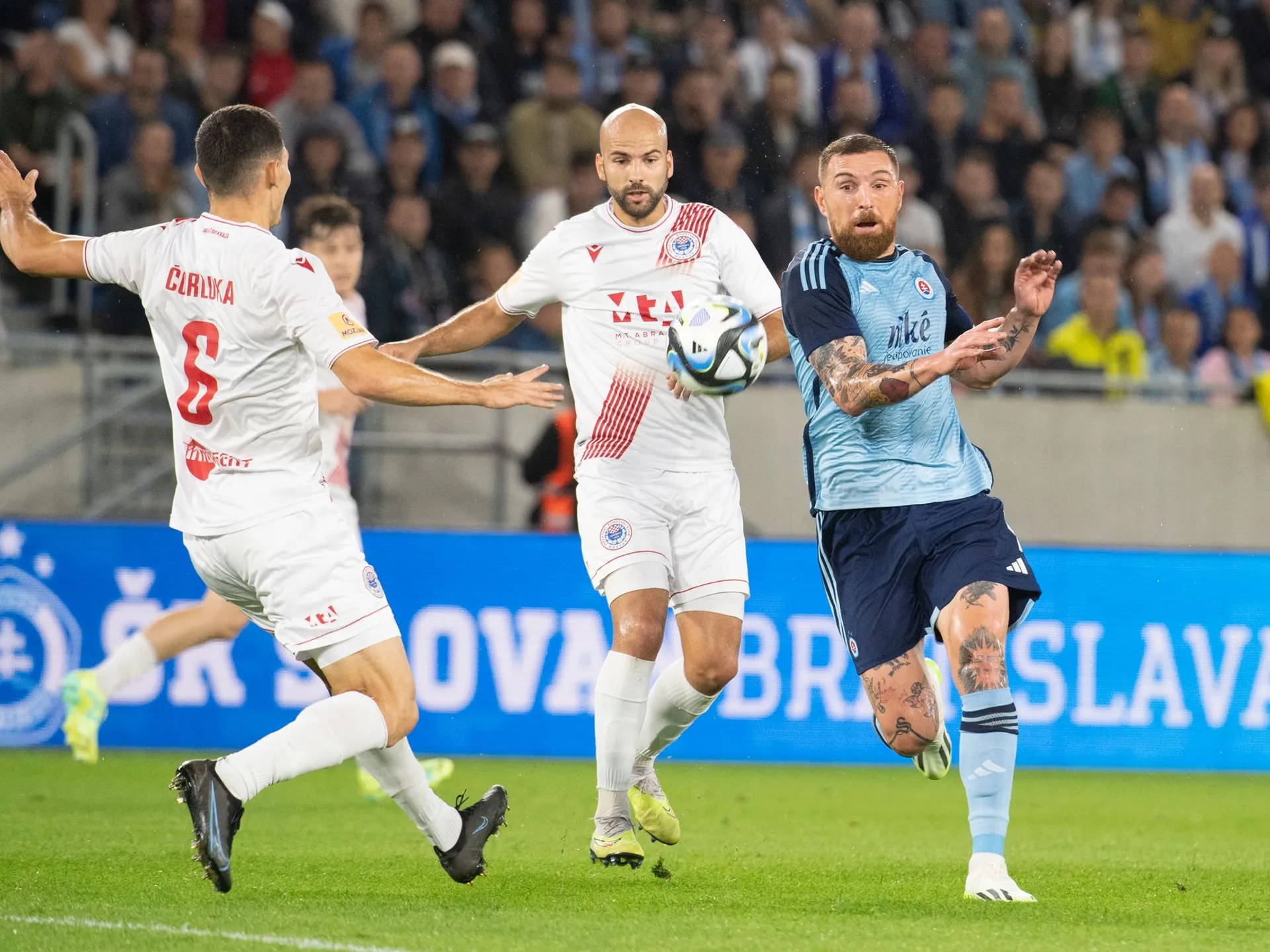 Na snímke sprava Guram Kašia (ŠK Slovan), Dario Čanadjija a Josip Čorluka (obaja Zrinjski) bojujú o loptu v odvetnom zápase 2. predkola Ligy majstrov ŠK Slovan Bratislava - HŠK Zrinjski Mostar v Bratislave v utorok 1. augusta 2023. 