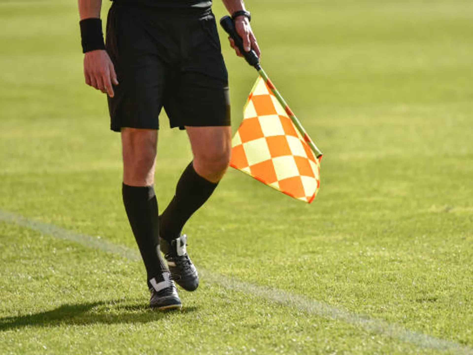 Legs and flag of assistant football referee