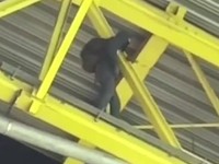 Zamaskovaný muž na streche štadióna počas zápasu Nemecko - Dánsko na EURO 2024