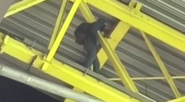 Zamaskovaný muž na streche štadióna počas zápasu Nemecko - Dánsko na EURO 2024